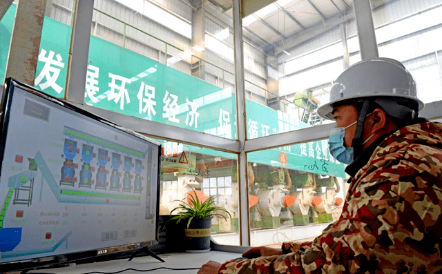 淮南市壽縣一家顆粒廠工人正在操控秸稈顆粒機械設備加工秸稈，生產生物燃料